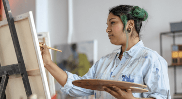 Girl with green hair painting on an easel