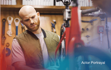 Actor portrayal: Man working on a bicycle in a shop