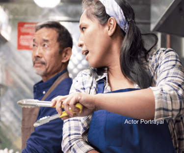 Actor portrayal: woman holding tongs while working on a food truc